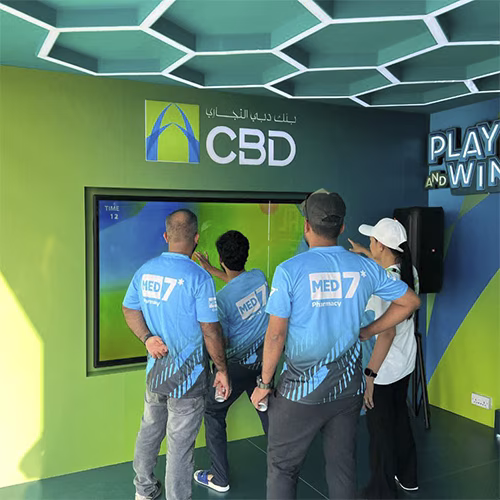 Interactive multi-level touch screen game rental at Dubai 30x30 event, showing guests engaged in a gamified fitness and financial literacy challenge.