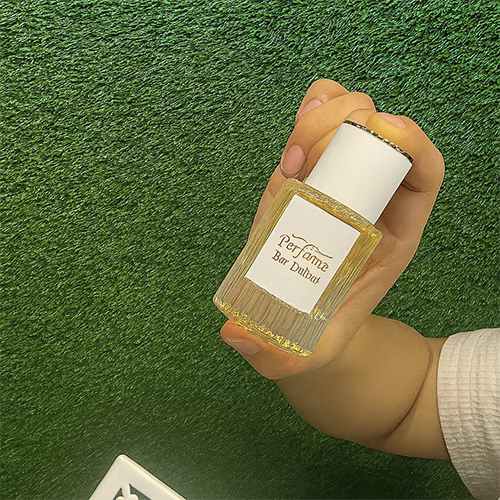 Perfume Booth setup in Dubai featuring a branded fragrance bar with colorful dispensers, interactive screen, and artificial grass backdrop for events and exhibitions
