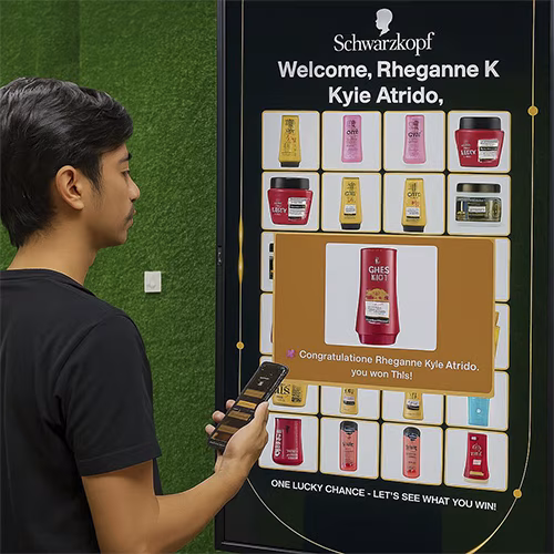 Guest playing Scan & Win interactive game by scanning QR code at a mall activation event in Dubai, with live name display and prize reveal on a big screen.