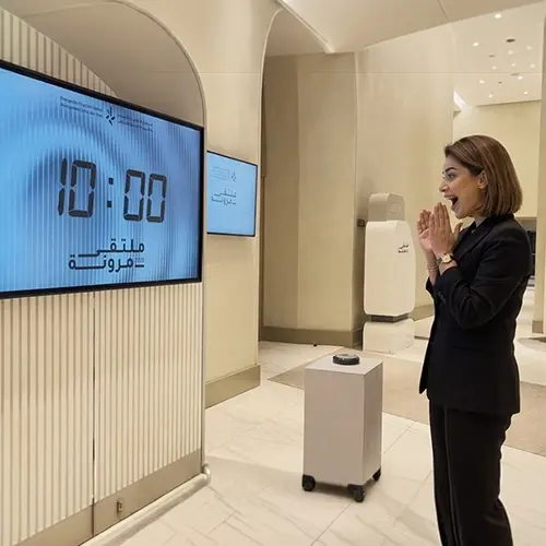 Guests playing Stop the Time interactive stopwatch game at a corporate event booth in Dubai, engaging with branded screen and trying to press the button at the perfect moment