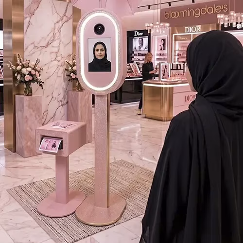 Guests having fun with quirky props inside a vintage strip photo booth by Mirror Booth Dubai.