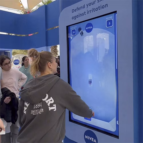 Guests playing the interactive Catch and Dodge game at a Niveae event in Dubai. Custom branded screen with data capture for exhibition marketing