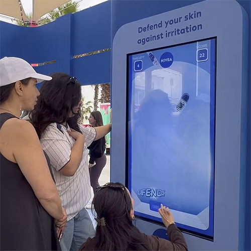 Guests playing the interactive Catch and Dodge game at a Niveae event in Dubai. Custom branded screen with data capture for exhibition marketing