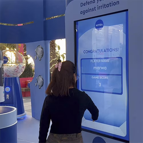 Guests playing the interactive Catch and Dodge game at a Niveae event in Dubai. Custom branded screen with data capture for exhibition marketing