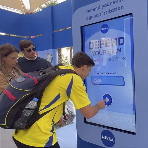 Guests playing the interactive Catch and Dodge game at a Niveae event in Dubai. Custom branded screen with data capture for exhibition marketing