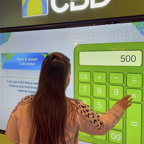 People playing a multi-level interactive financial literacy game at a brand activation event in Dubai, learning how to save and invest money.