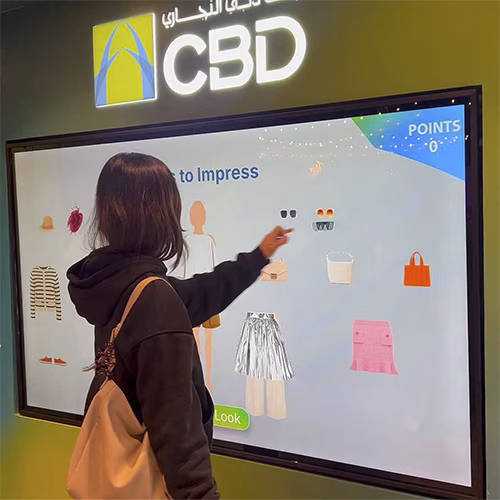 People playing a multi-level interactive financial literacy game at a brand activation event in Dubai, learning how to save and invest money.
