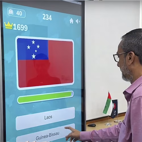Participants playing the interactive Guess the Flag game at an event, engaging with a fun, branded quiz experience that tests geographical knowledge in a lively setting.