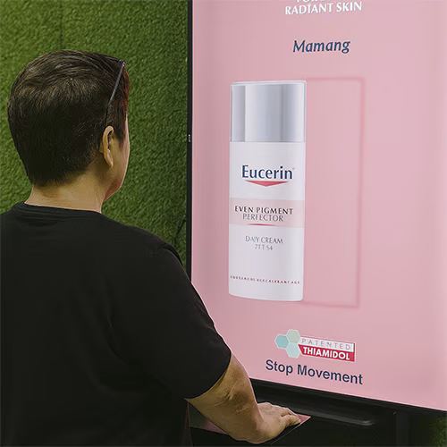 Guests playing Freeze the Frame interactive game at a corporate event in Dubai, focusing on screen visuals and pressing the button to stop the image at the perfect moment.