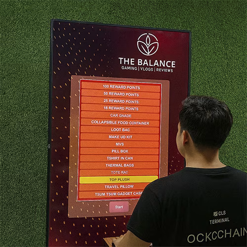 Guest playing interactive event game at exhibition booth in Dubai, pressing button to win prize, with branded screen display and selfie sharing feature for engagement.