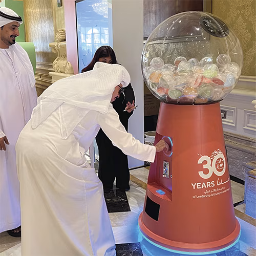 Interactive Gumball Machine at a Dubai brand activation event. Guests are playing and engaging with the sleek machine, creating memorable experiences.
