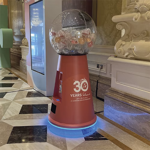 Interactive Gumball Machine at a Dubai brand activation event. Guests are playing and engaging with the sleek machine, creating memorable experiences.