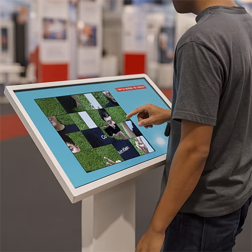 Guest solving a scrambled photo puzzle on a touchscreen at an event. Interactive image puzzle game rental for exhibitions, corporate events, and activations in Dubai.