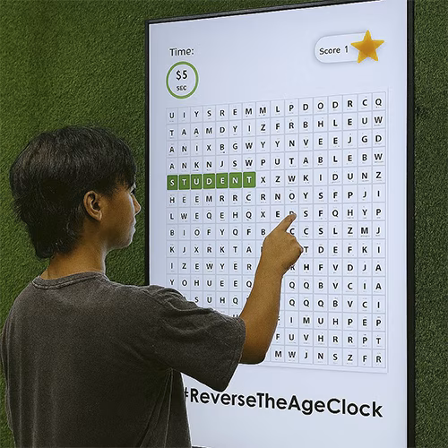 Guest playing interactive word search game at corporate event in Dubai, with branded screen, vibrant green backdrop