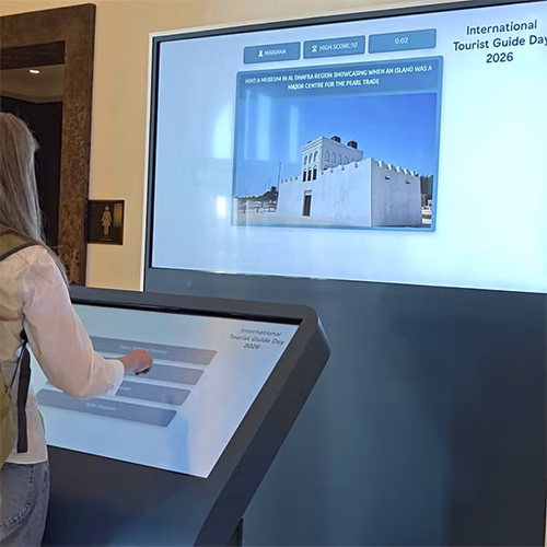 Multi-screen interactive UAE landmark guessing game display with custom branded interface for immersive event activation and digital tourism engagement.