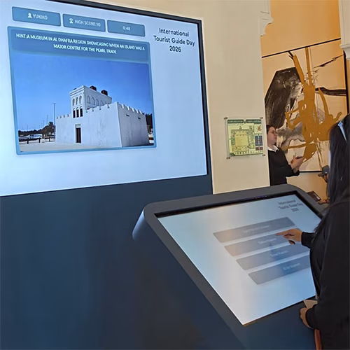 Multi-screen interactive UAE landmark guessing game display with custom branded interface for immersive event activation and digital tourism engagement.