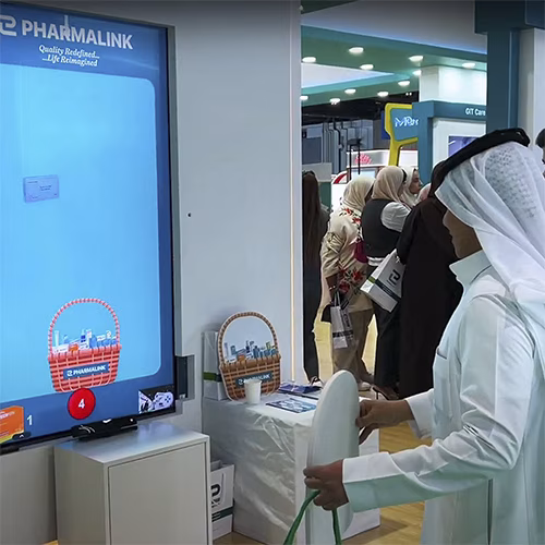 Player using body to slash branded items in a motion sensor game at exhibition in Dubai