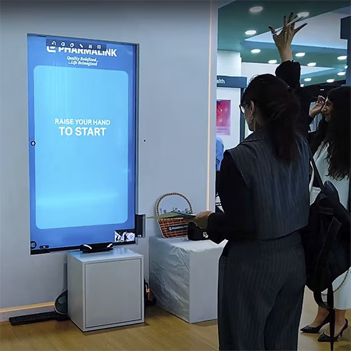 Player using body to slash branded items in a motion sensor game at exhibition in Dubai