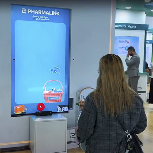 Player using body to slash branded items in a motion sensor game at exhibition in Dubai