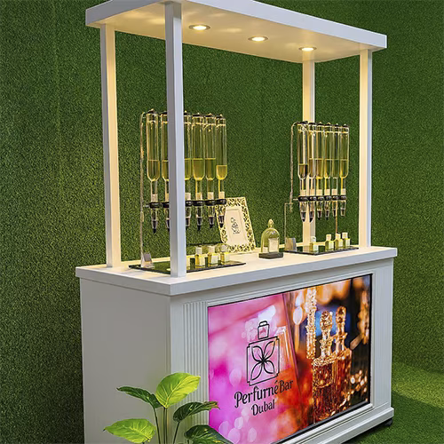 Perfume Booth setup in Dubai featuring a branded fragrance bar with colorful dispensers, interactive screen, and artificial grass backdrop for events and exhibitions