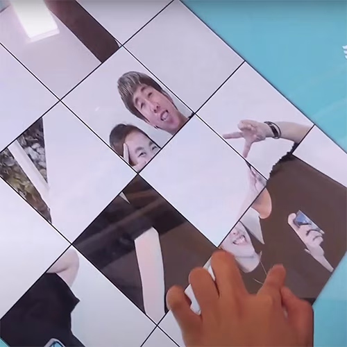 Player solving a shuffled photo puzzle of their face during an interactive event challenge.