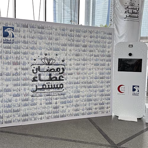 Guests adding photos to a digital mosaic wall, creating a collaborative image masterpiece at a live event.