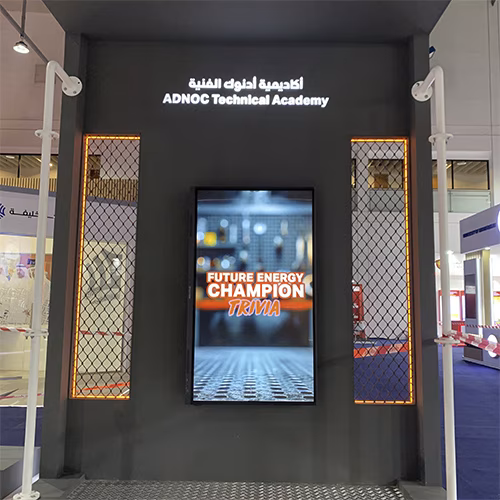 Students and guests play the Plinko Trivia Challenge at the ADNOC Technical Academy booth during a busy Dubai event