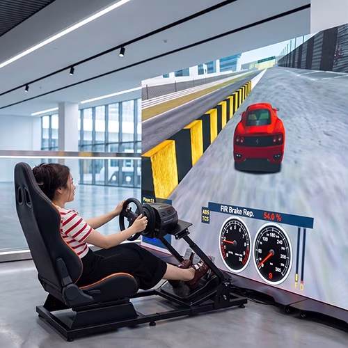 Woman using a pro-grade racing simulator setup with a high-precision wheel, pedals, black bucket seat, and large video screen showing a sports car track experience.