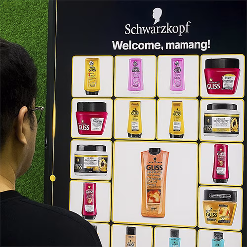 Guest playing Scan & Win interactive game by scanning QR code at a mall activation event in Dubai, with live name display and prize reveal on a big screen.