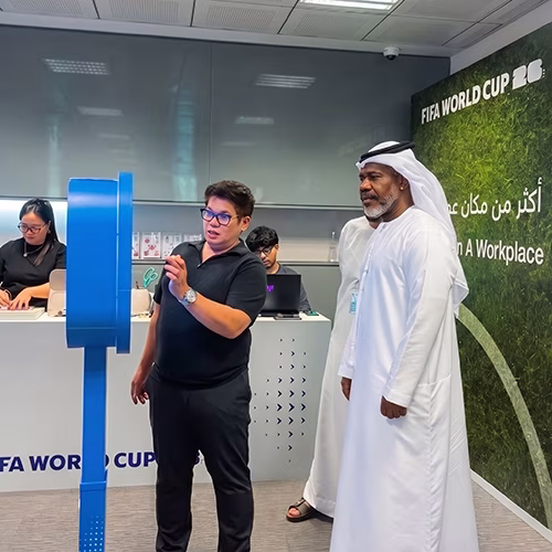 Guest holding a custom-printed sheet of branded AI branded stickers at a Dubai corporate event