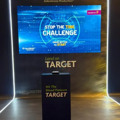 Guests playing Stop the Time interactive stopwatch game at a corporate event booth in Dubai, engaging with branded screen and trying to press the button at the perfect moment