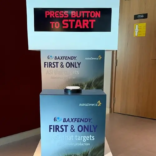 Guests playing Stop the Time interactive stopwatch game at a corporate event booth in Dubai, engaging with branded screen and trying to press the button at the perfect moment