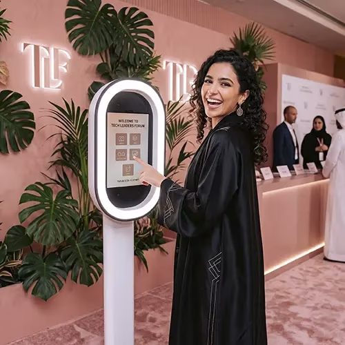Guests having fun with quirky props inside a vintage strip photo booth by Mirror Booth Dubai.