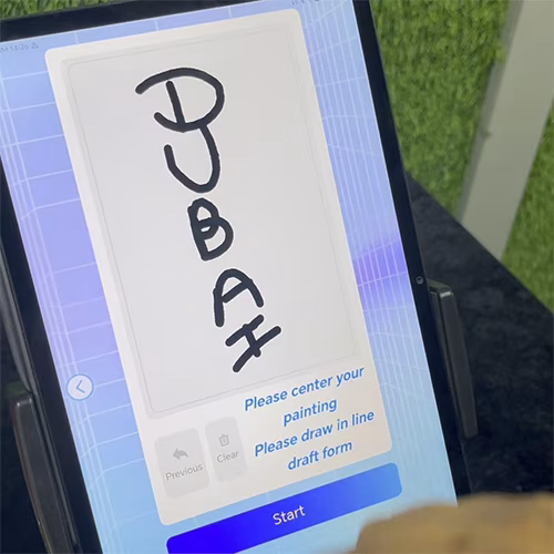 Guests using the AI Sugar Painting Robot in UAE, watching it create edible art and enjoying unique designs at events, kids activities, and parties.