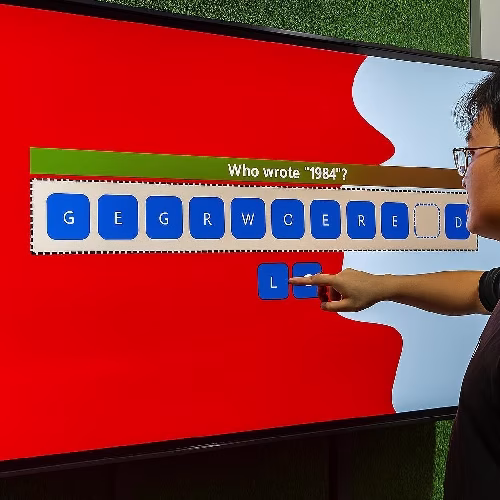 Guest playing word scramble game on large touchscreen at Dubai event with branded graphics and green artificial grass wall background.