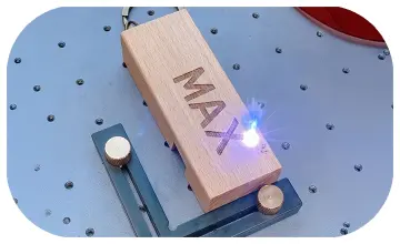 Close-up of a high-speed laser engraving machine personalizing a luxury perfume bottle at a premium event in Dubai.