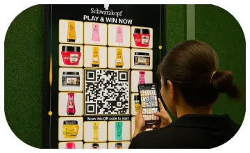 Guest playing Scan & Win interactive game by scanning QR code at a mall activation event in Dubai, with live name display and prize reveal on a big screen.
